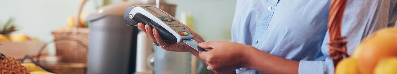 person ssing credit card chip reader, inside of store.