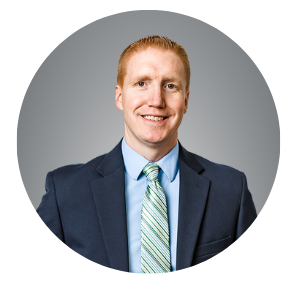 Picture of a man standing wearing a suit. 