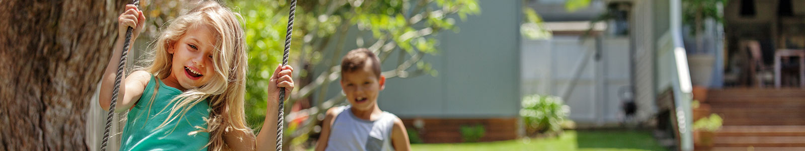 children playing on a tree swing outside.