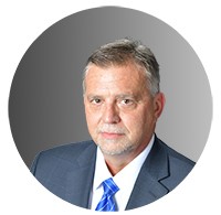 Picture of a man in a suit with a slight smirk. 