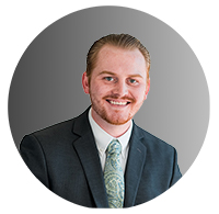 Picture of a young man wearing a suit and smiling. 