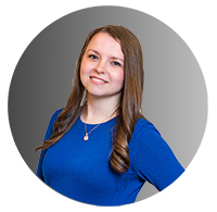 Picture of a young woman standing and smiling. 
