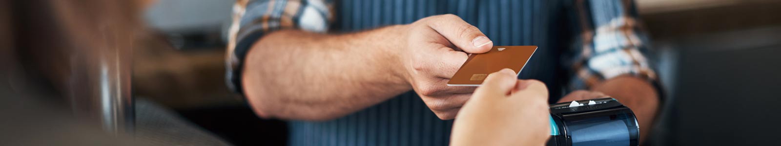 one person handing debit card to  another perosn to make payment at store.