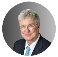 Picture of an older man wearing a suit, smiling. 